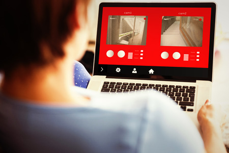 Pregnant woman using her laptop against home control systemの写真素材