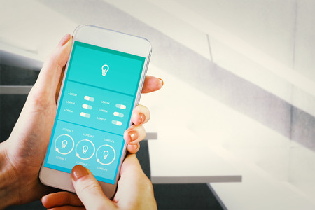 Hand holding smartphone against white staircase in a home