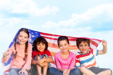 Children with american flag against blue skyの写真素材
