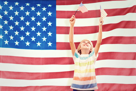 Cute boy with american flag against rippled us flagの写真素材