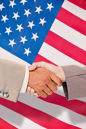 Side view of business peoples hands shaking against greyの写真素材