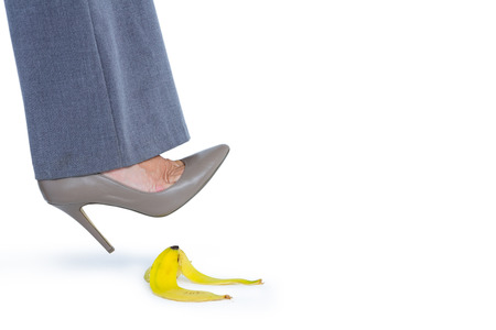 Woman with heel shoes walking on banana on white backgroundの写真素材