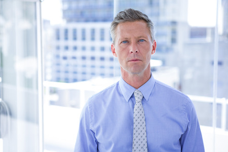 Thinking businessman looking at the camera in the officeの写真素材