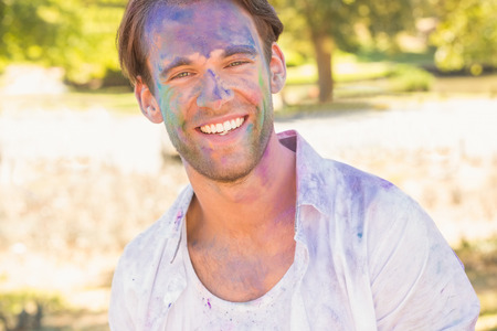 Young man having fun with powder paint on a sunny day