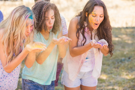 Young women having fun with powder paint on a sunny dayの写真素材