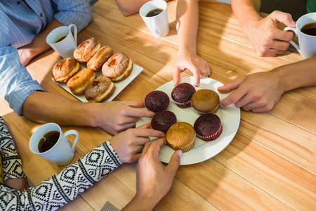 Business people taking cakes on table after lunch in the officeの写真素材