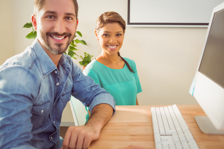 Portrait of two colleague using a computer in the office