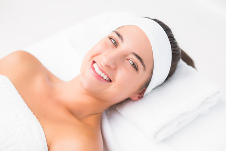Beautiful young woman on massage table at spa centerの写真素材