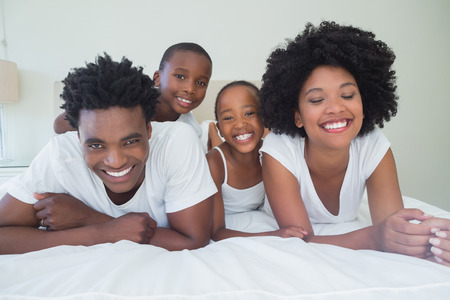 Happy family having fun together at home in bedroomの写真素材