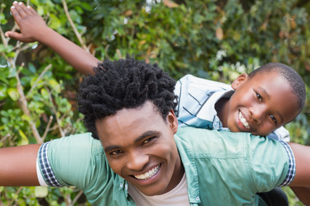 Happy father and son having fun together in the garden at homeの写真素材