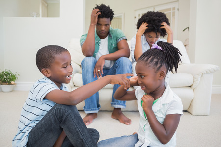 Frustrated parents watching their children fight at home in the living roomの写真素材