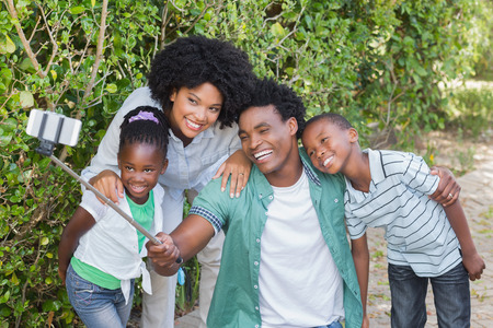 Happy family taking a selfie in the garden at homeの写真素材