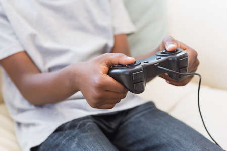 Little boy playing video games at home in the living room
