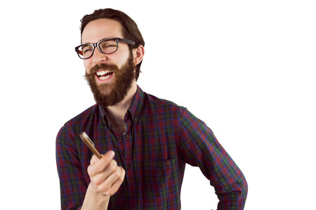 Handsome hipster laughing and pointing on white backgroundの写真素材