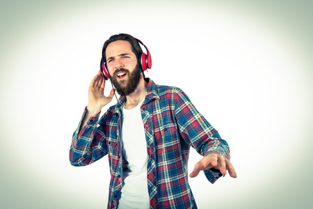 Handsome hipster enjoying listening to music on vignette backgroundの写真素材