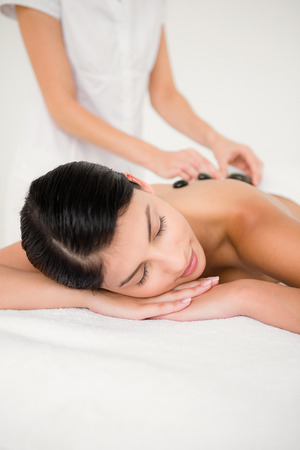 Pretty woman receiving a hot stone massage at the health spaの写真素材