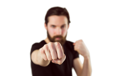 Handsome hipster punching at camera on white backgroundの写真素材