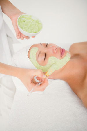 Beautiful brunette getting a facial treatment at the health spaの写真素材