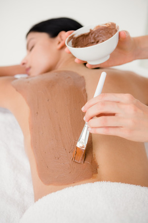 Beautiful brunette enjoying a chocolate beauty treatment at the health spaの写真素材