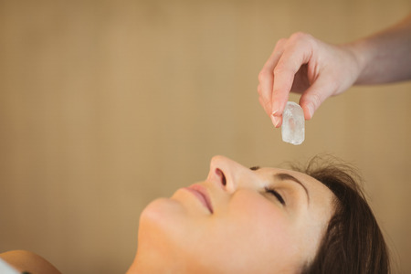 Young woman at crystal healing session in therapy roomの写真素材