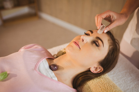 Young woman at crystal healing session in therapy roomの写真素材