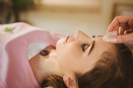 Young woman at crystal healing session in therapy roomの写真素材