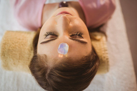 Young woman at crystal healing session in therapy roomの写真素材