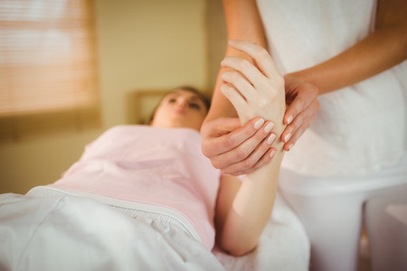 Young woman getting hand massage in therapy roomの写真素材