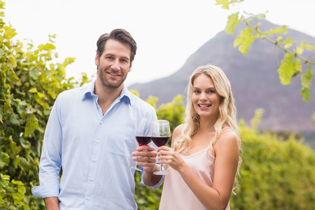 Young happy couple smiling at camera in the grape fieldsの写真素材