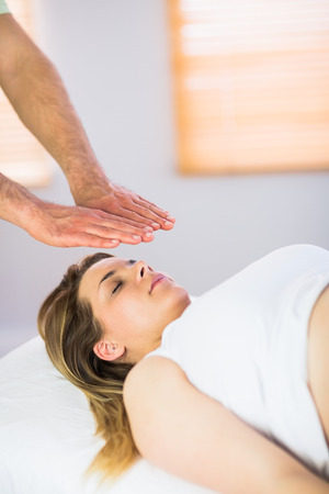 Close up view of pregnant woman getting reiki treatment in a studioの写真素材