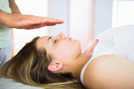Close up view of pregnant woman getting reiki treatment in a studioの写真素材