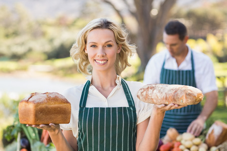 Portrait of a smiling farmer woman holding breadsの写真素材