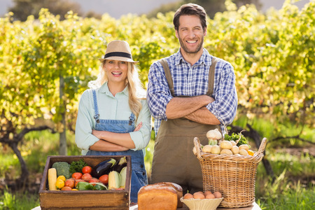 Portrait of a happy farmer couple with arms crossedの写真素材