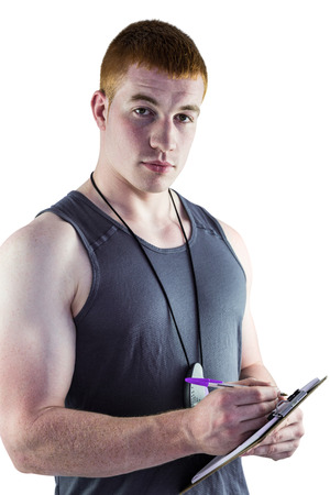 Portrait of a fit personal trainer writing on clipboardの写真素材