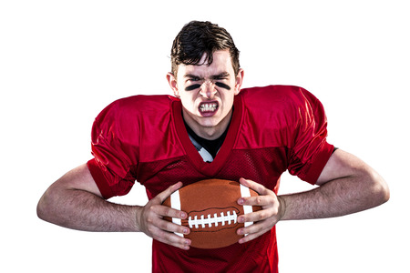 Portrait of an american football player crushing a ballの写真素材
