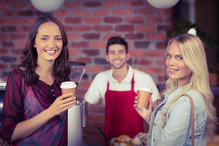 Portrait of a waiter and two customers at the coffee shopの写真素材