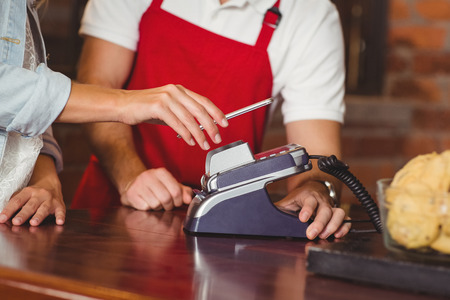 Close up customer hands making a mobile payment at the coffee shopの写真素材
