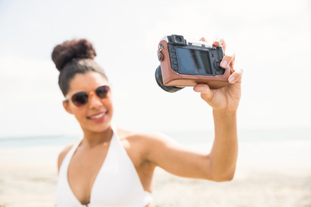 Pretty woman in bikini taking selfie at the beachの写真素材
