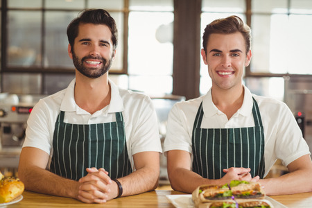 Portrait of two smiling baristas at the coffee shopの写真素材