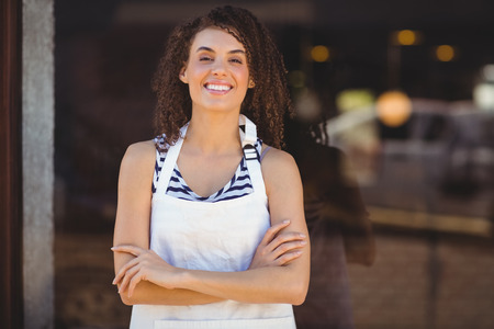 Portrait of a waitress with arms crossed at the coffee shopの写真素材