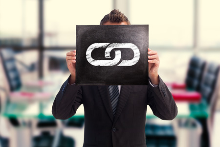 Businessman showing board against empty corporate meeting roomの写真素材