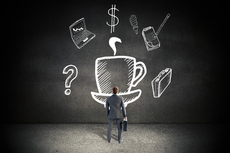 Businessman standing with his briefcase against black wallの写真素材