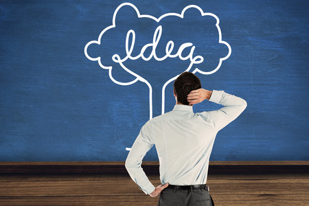 Thinking businessman with hand on head against blue roomの写真素材