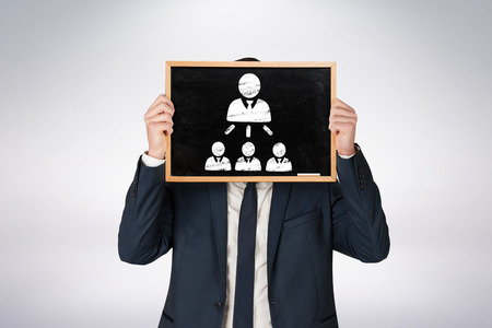 Businessman holding board against grey backgroundの写真素材