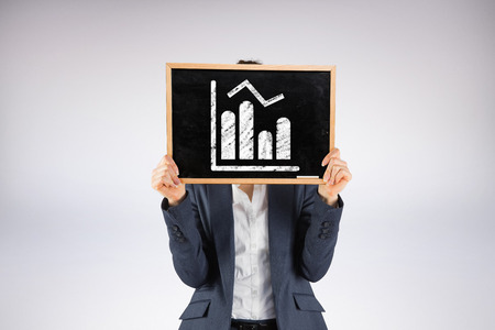 Businesswoman showing board against grey backgroundの写真素材