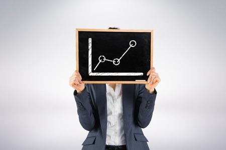 Businesswoman showing board against grey backgroundの写真素材