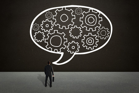 Businessman standing with his briefcase against dark roomの写真素材