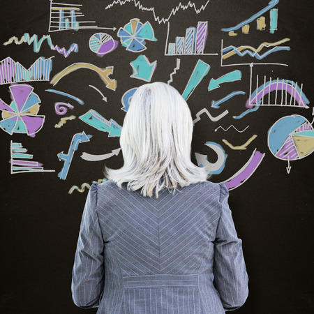 businesswoman against blackboardの写真素材