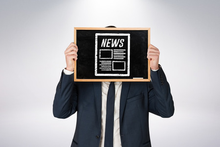 Businessman holding board against grey backgroundの写真素材