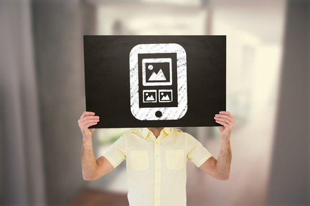 Casual man showing board against stylish modern home interior with staircaseの写真素材